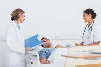 Врачи беседуют с пациентом в больничной палате